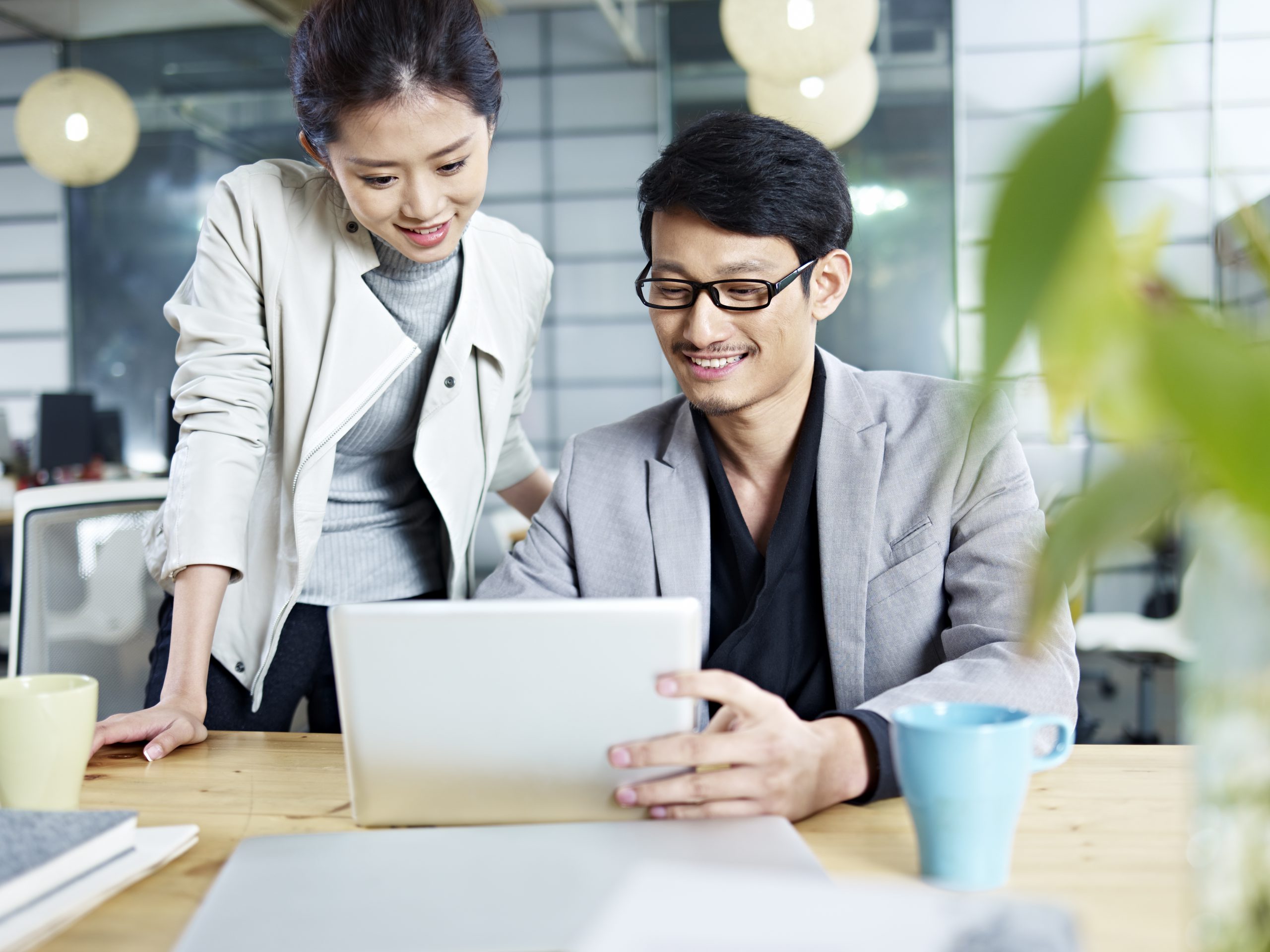 Young,Asian,Business,People,Sitting,At,Desk,Working,Together,Using 薪酬外包中国