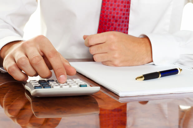 tax-compliance-meaning man with calculator tax compliance meaning